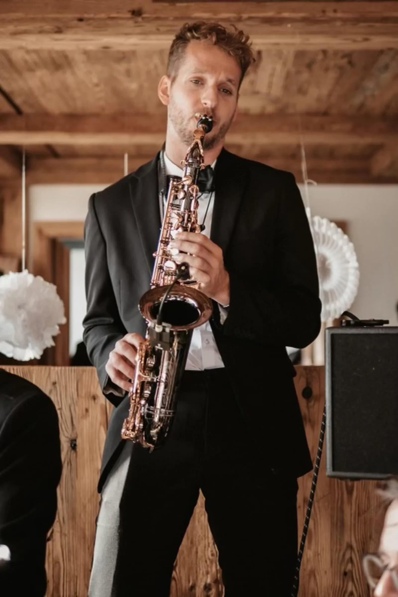 Pascal spielt Saxophon in rustikaler Hochzeitslocation